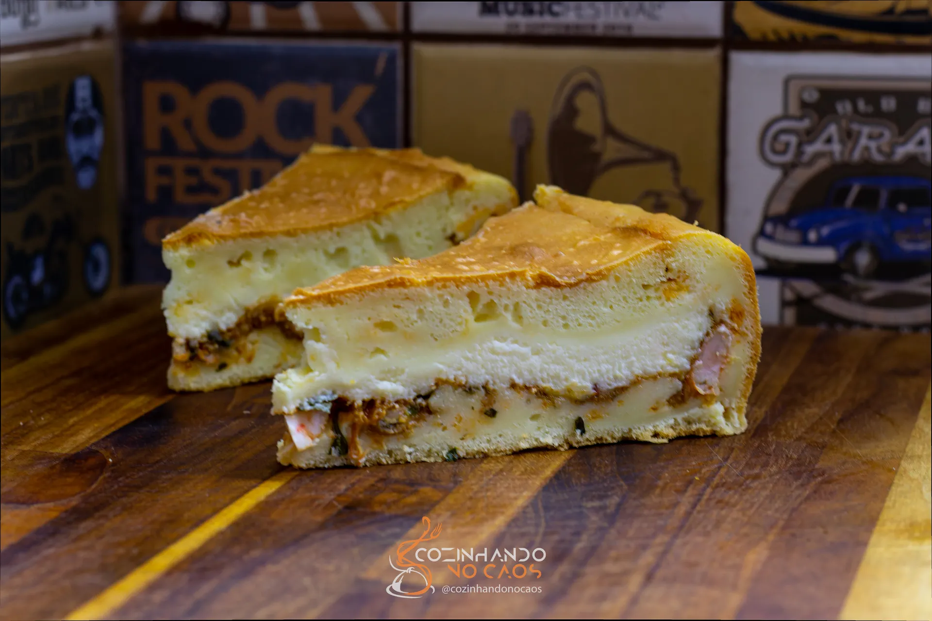 Duas fatias de torta salgada com recheio cremoso sobre tábua de madeira